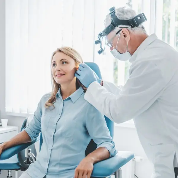 audiologist cleaning a patients ear