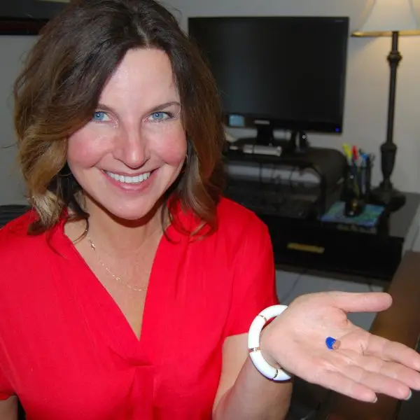 heather holding a hearing aid