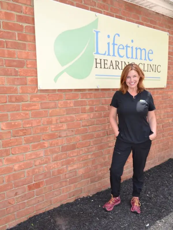 Heather in front of the lifetime hearing sign